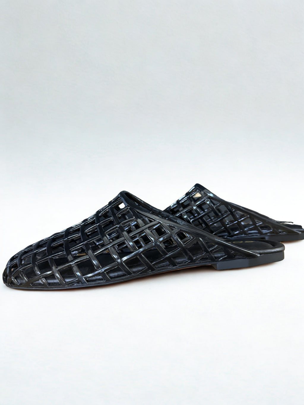 Black woven sandals on a white background