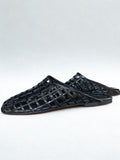 Black woven sandals on a white background