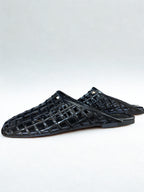Black woven sandals on a white background
