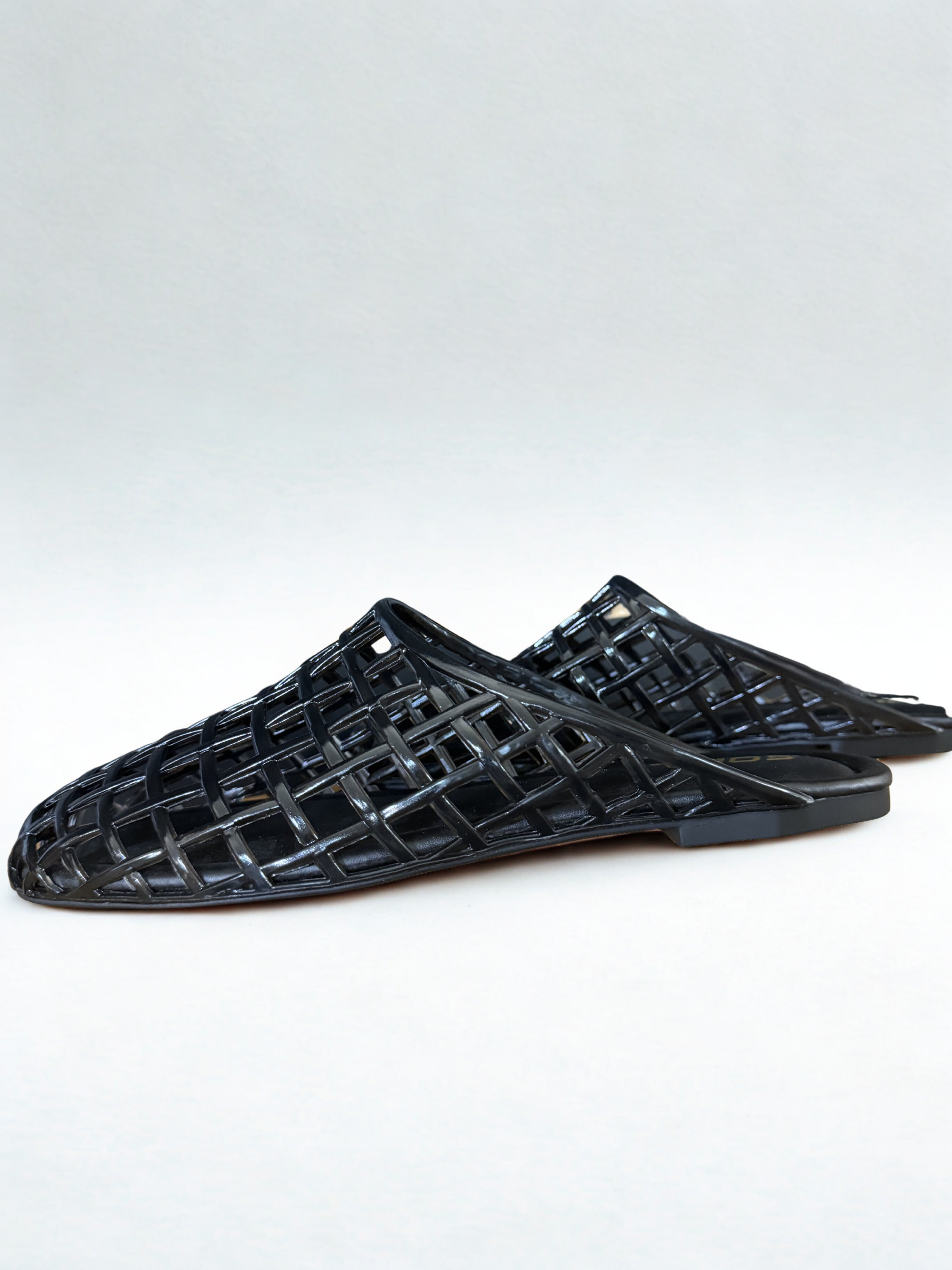 Black woven sandals on a white background
