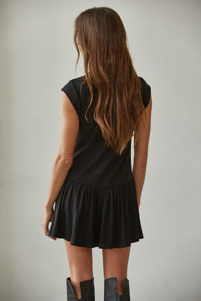 Woman wearing a black dress with a plain background
