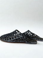 Black woven sandals on a white background