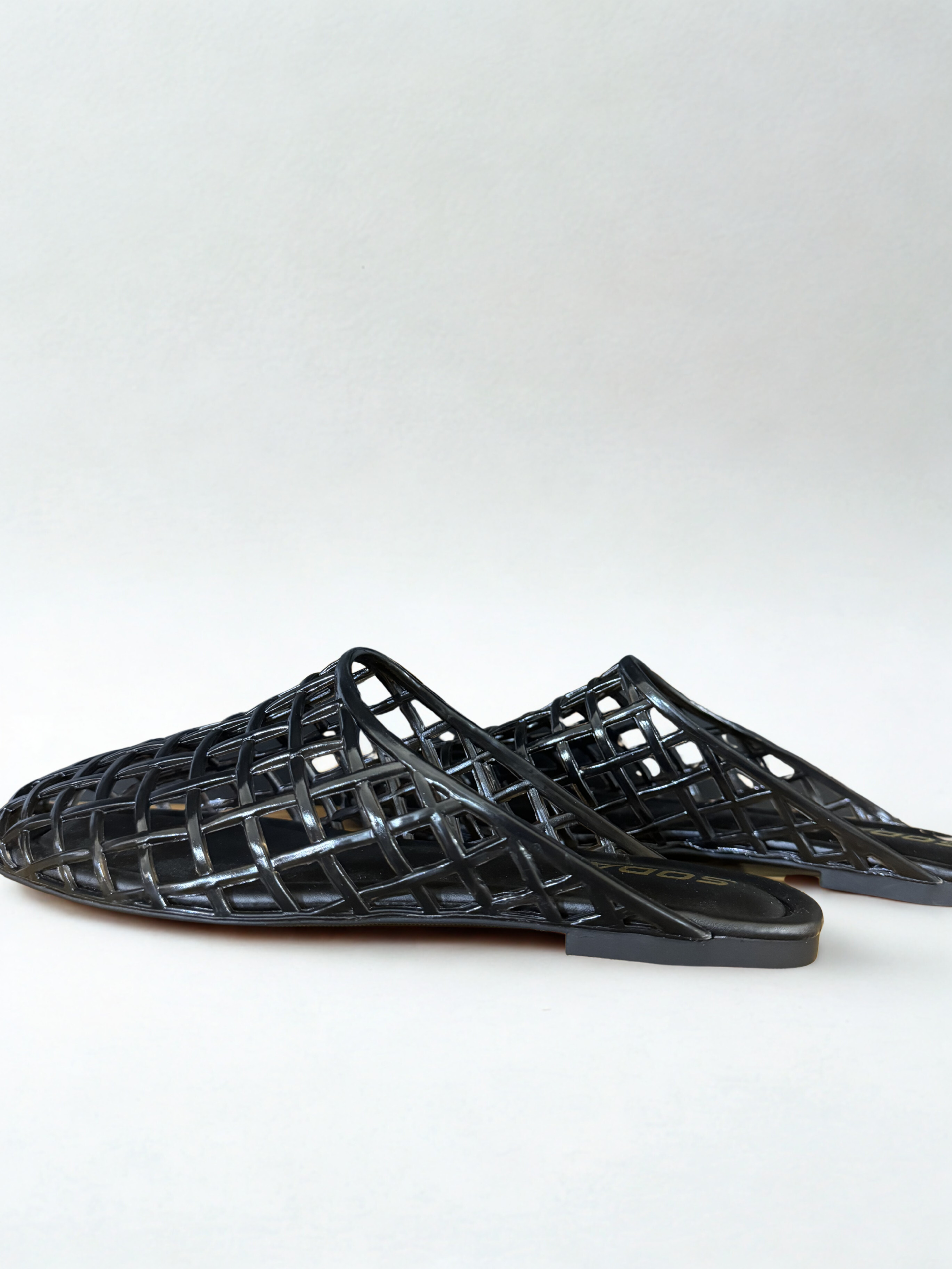 Black woven sandals on a white background